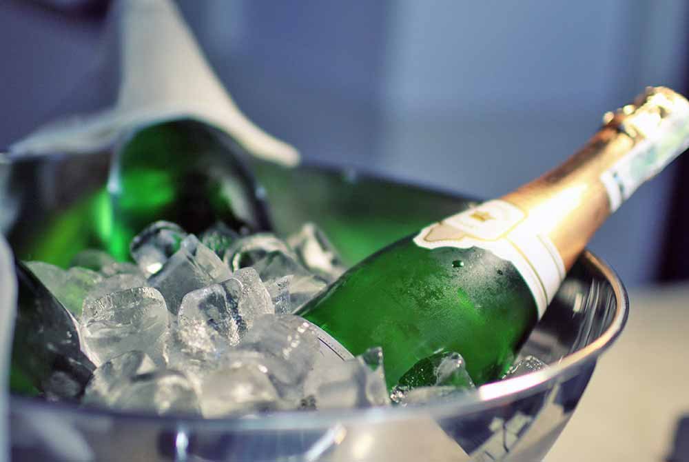Two bottles of champagne chilling in a metal bucket filled with ice as part of San Antonio getaway packages.